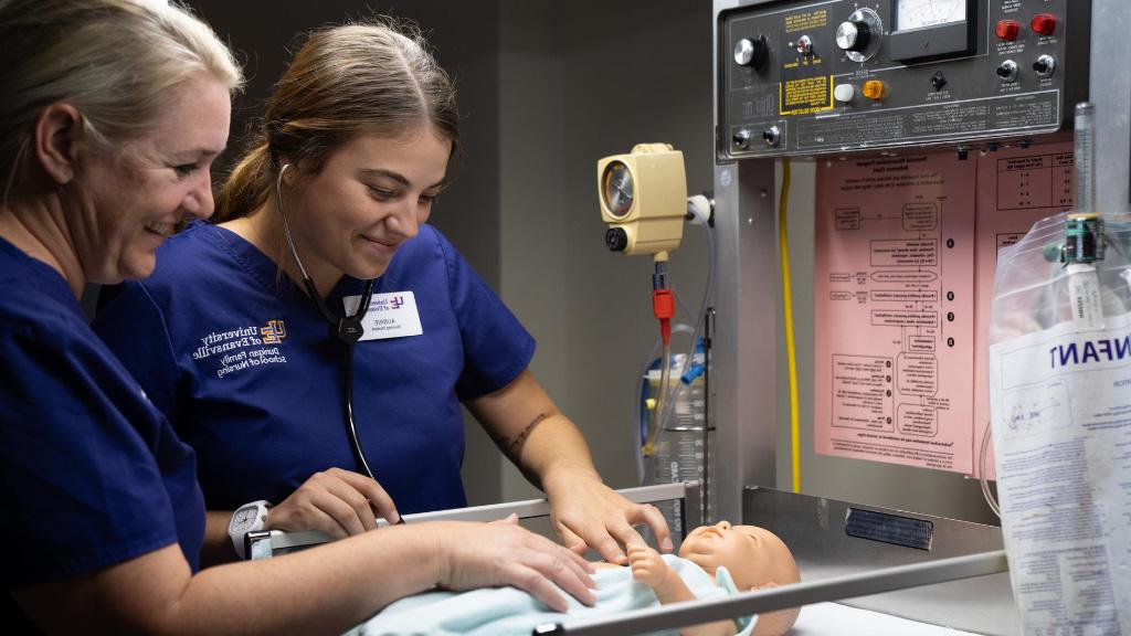 Nursing student and faculty with sim baby